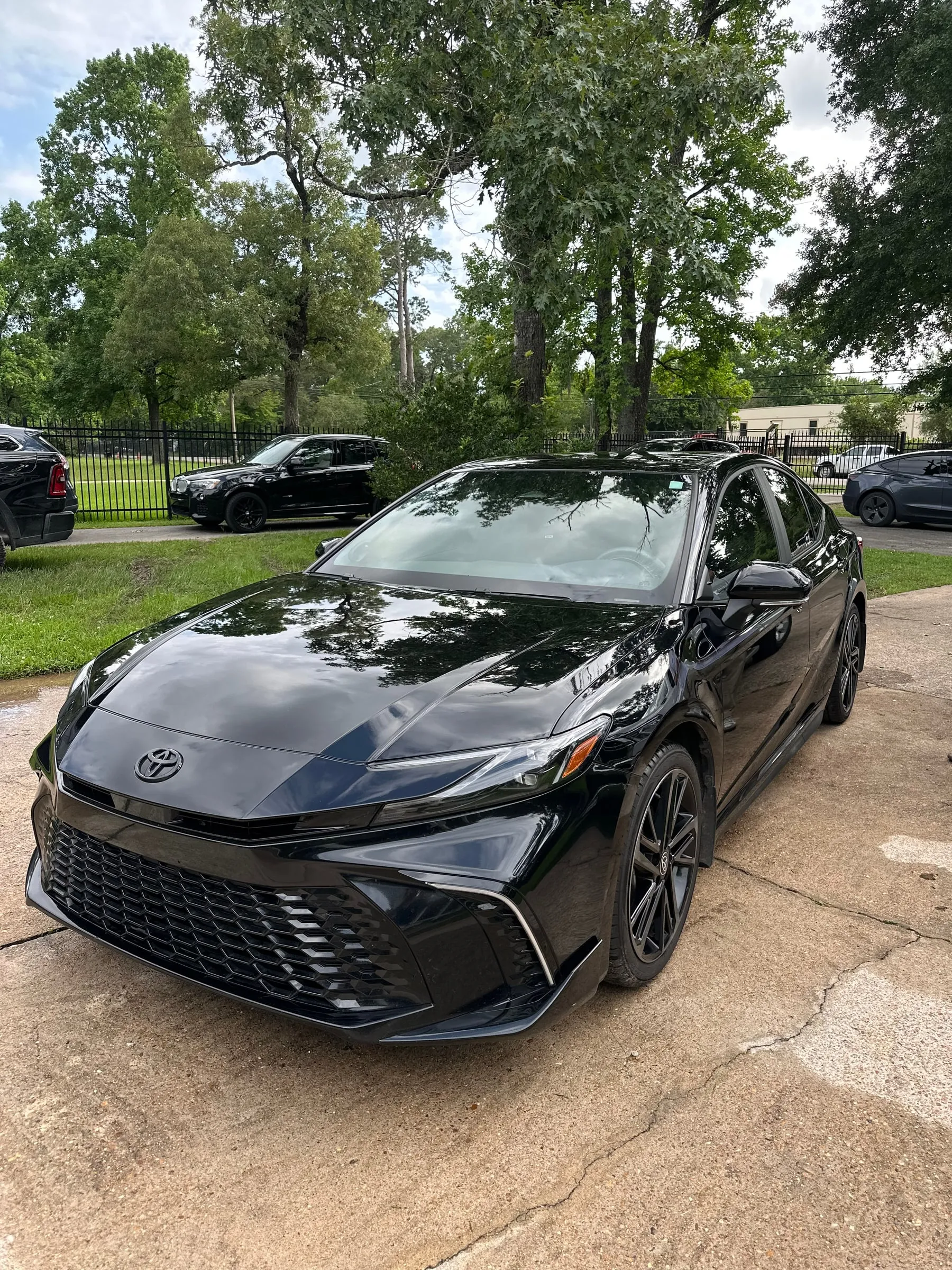 Black Toyota sedan with mirror-like reflections after ceramic coating